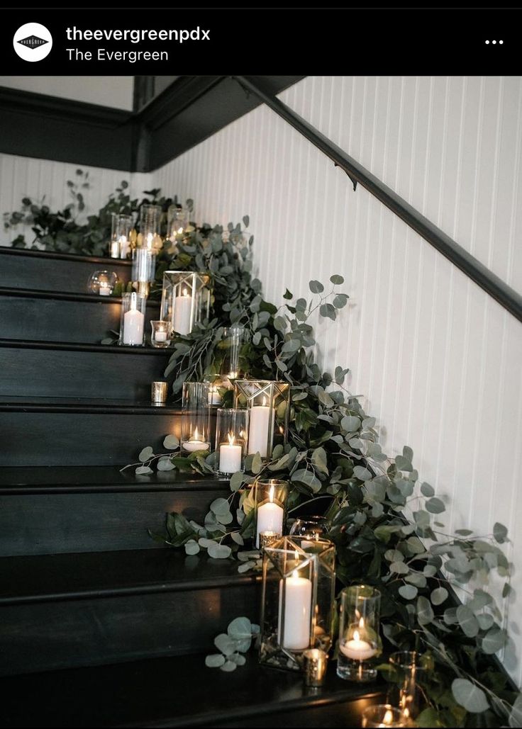 candles and greenery are lined up on the stairs