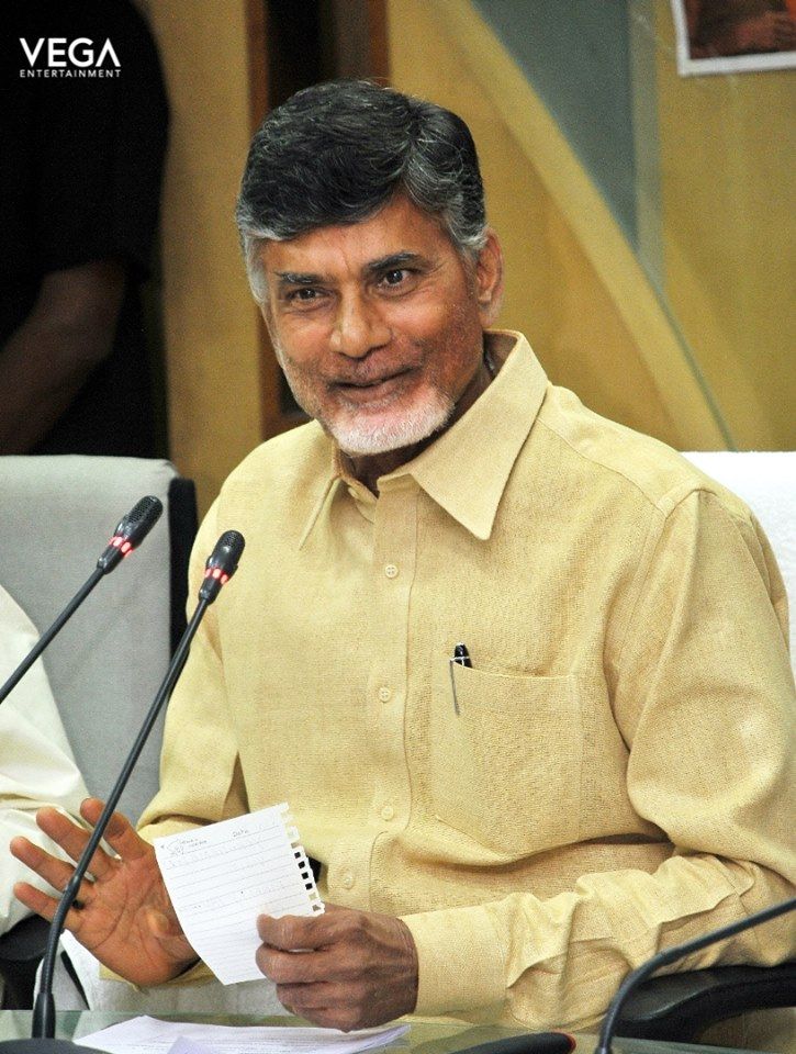 a man sitting in front of a microphone holding a piece of paper