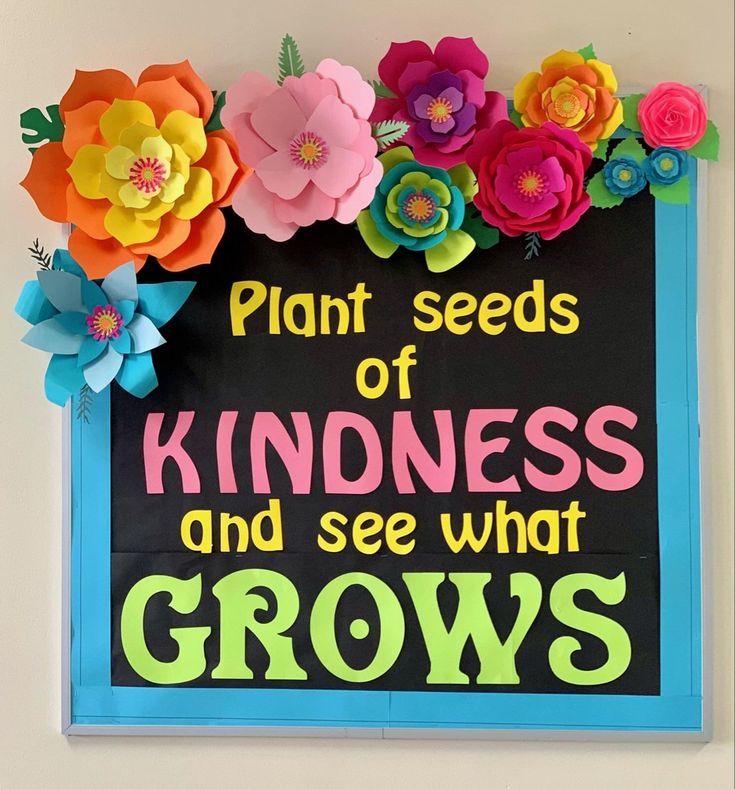 a sign that says plant seeds of kindness and see what grows on the board with flowers