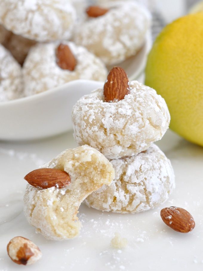 almonds and powdered sugar are stacked on top of each other in front of a lemon