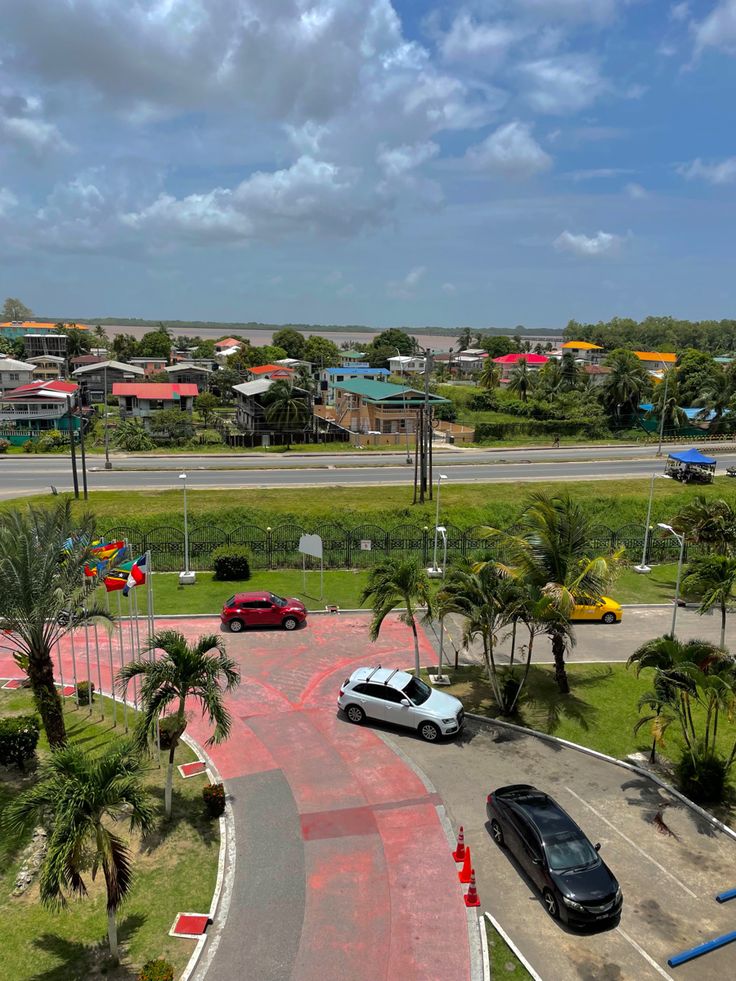 an aerial view of a parking lot with cars parked on the street and palm trees