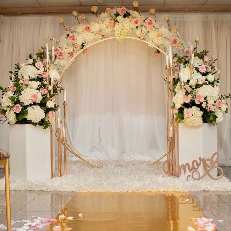 a wedding arch decorated with flowers and candles