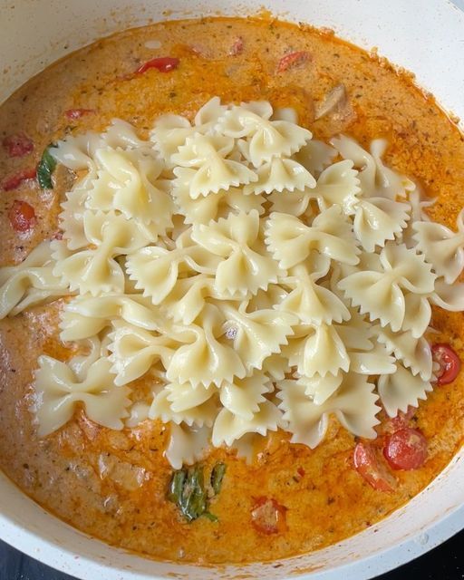 a bowl filled with pasta and sauce on top of a stove