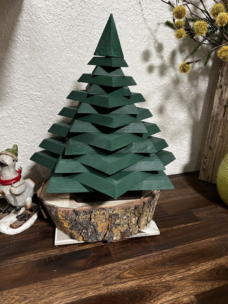 a small wooden christmas tree sitting on top of a table