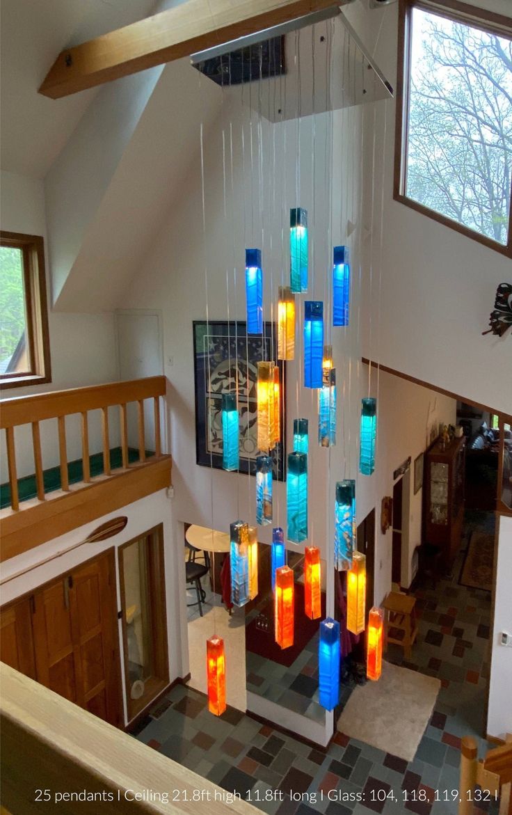 a chandelier made out of glass bottles hanging from the ceiling in a house