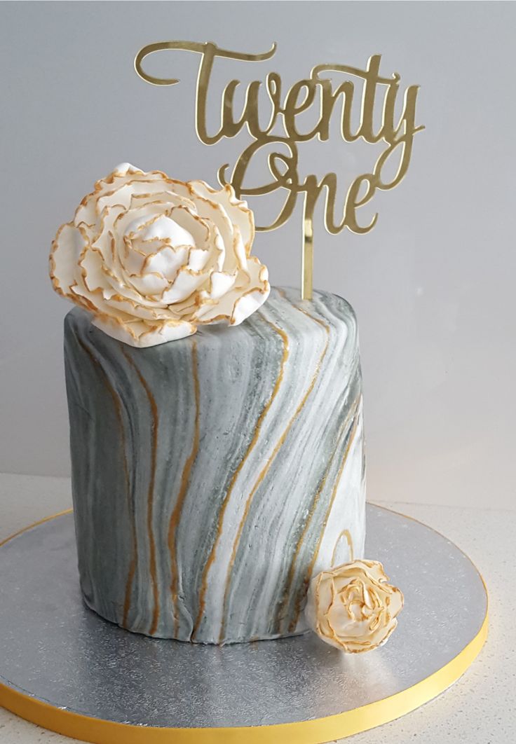 there is a cake that has been decorated with marble and gold decorations on the top