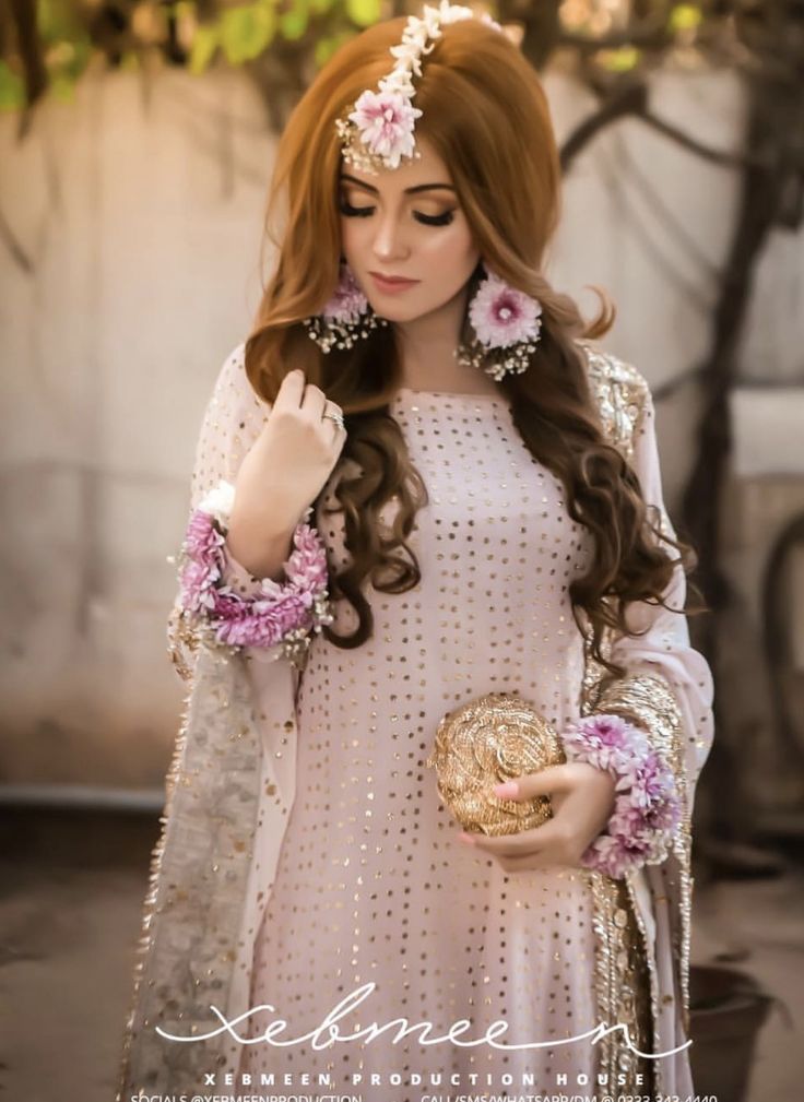 a woman with long brown hair wearing a white dress and holding a gold bowl in her hand