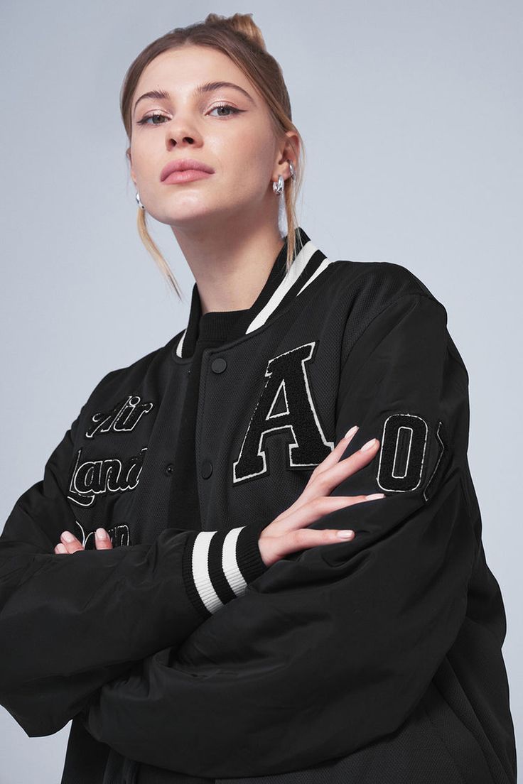 G.O.A.T Jacket - Black | Alo Yoga Black Outerwear With Baseball Collar And Logo Patch, Black Baseball Collar Outerwear With Logo Patch, Black Varsity Jacket With Baseball Collar And Logo Patch, Black Varsity Jacket With Embroidered Logo For Fall, Black Embroidered Logo Varsity Jacket For Fall, Fall Black Varsity Jacket With Embroidered Logo, Black Varsity Jacket With Logo Patch For College, Black Varsity Jacket With Logo Patch, Urban Fall Varsity Jacket With Logo Patch