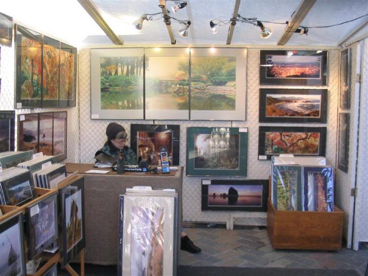 a room filled with lots of paintings and pictures on the walls, including one woman sitting at a desk