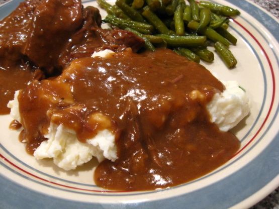 a plate with mashed potatoes, green beans and gravy