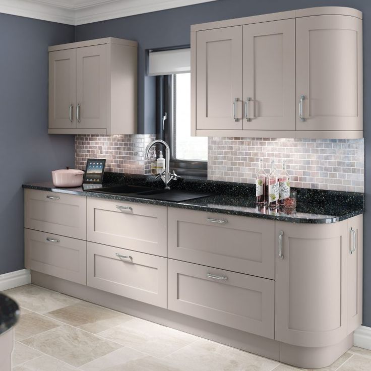 a kitchen with gray cabinets and black counter tops