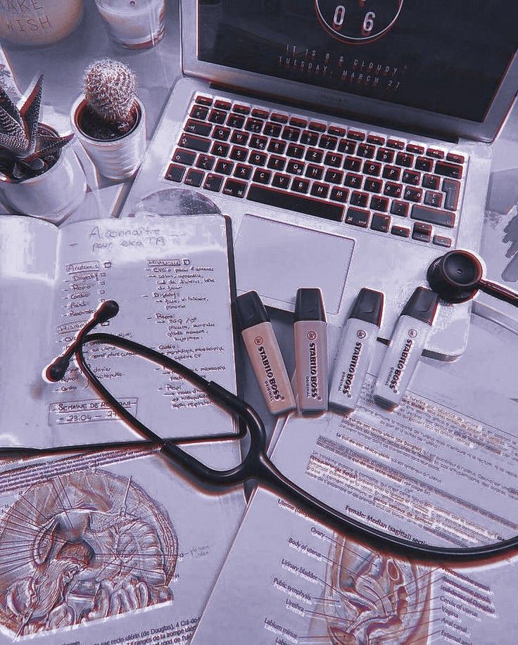 an open laptop computer sitting on top of a desk next to eyeglasses and other items