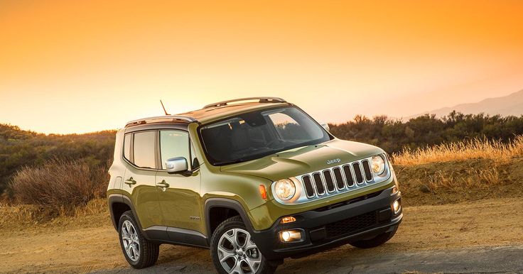 a green jeep is parked on the side of the road in front of an orange sky