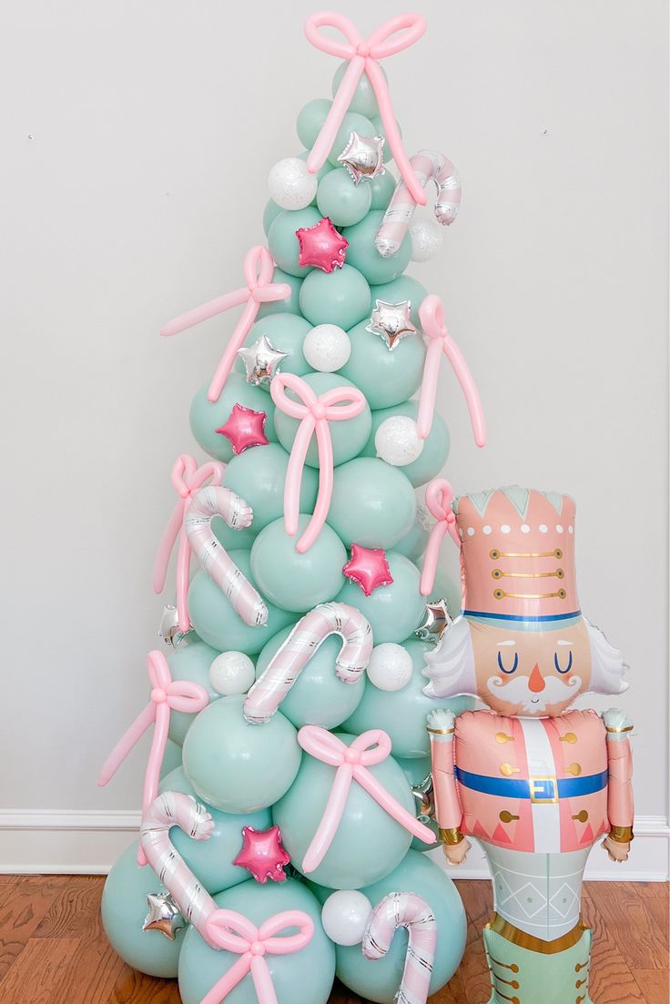 a balloon christmas tree next to a nutcracker