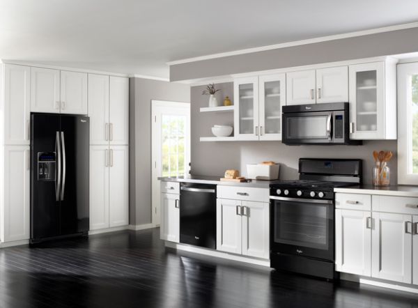 a kitchen with white cabinets and black appliances