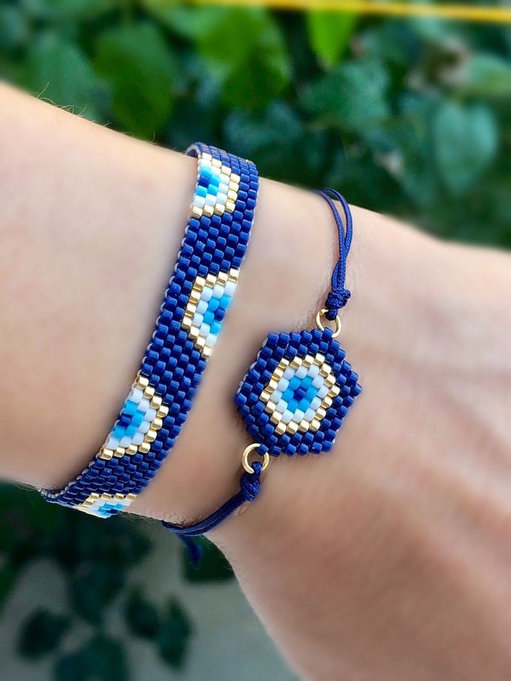 a woman's arm wearing a blue beaded bracelet with an evil eye charm