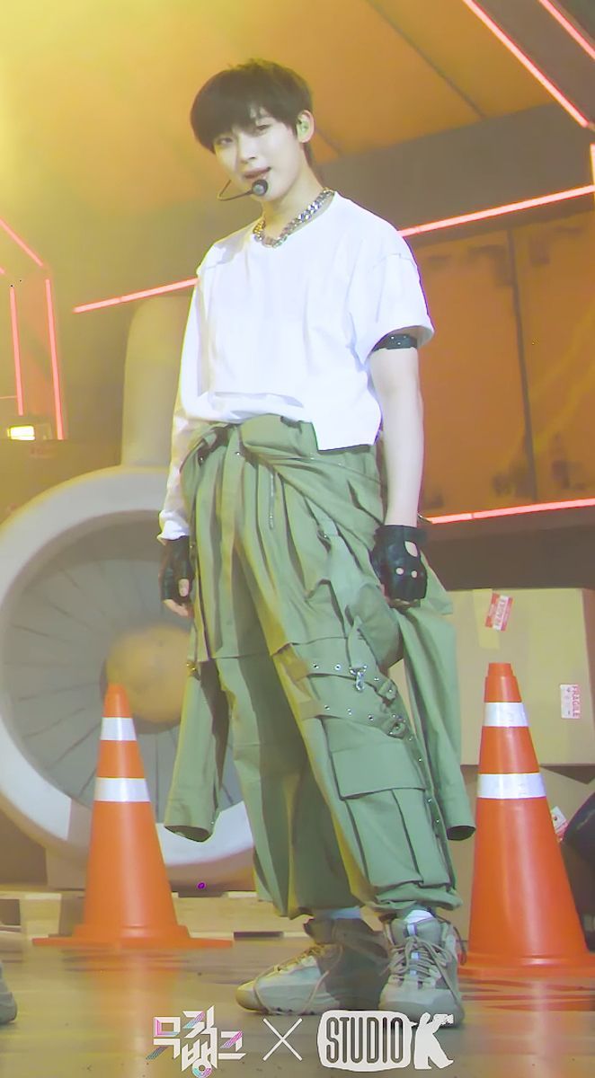 a young man standing in front of orange cones