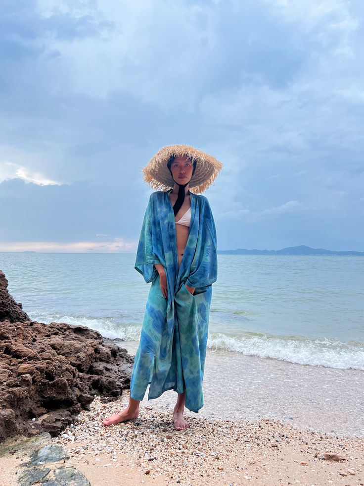 Enhance your everyday style with the subtle allure of patterns and colors in our Dragon Tie Dye Kimono Jacket, inspired by the ocean. This kimono robe effortlessly embodies chic resort-style vibes while ensuring comfort. Hand-stitched from 100% soft rayon fabric and meticulously tie-dyed by skilled artisans, it boasts both quality craftsmanship and artistic flair. With a dropped hemline and a flowing oversized fit, this long kimono jacket effortlessly infuses a laid-back, cool aesthetic into all Vacation Beach Cover-up Kimono With Kimono Sleeves, Blue Open Front Cover-up For Vacation, Beach Season Beachy Kimono For Day Out, Beachy Kimono For Beach Season, Beachy Kimono For Beach Season And Day Out, Beachy Kimono For Beach Season Day Out, Relaxed Fit Robe For Beach In Spring, Spring Beach Robe With Relaxed Fit, Relaxed Fit Robe For Beach And Spring