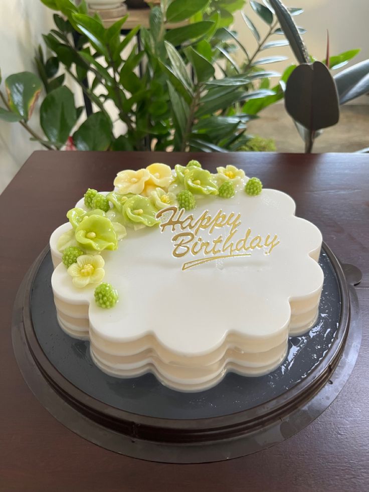 a birthday cake decorated with flowers and the words happy birthday on it's side