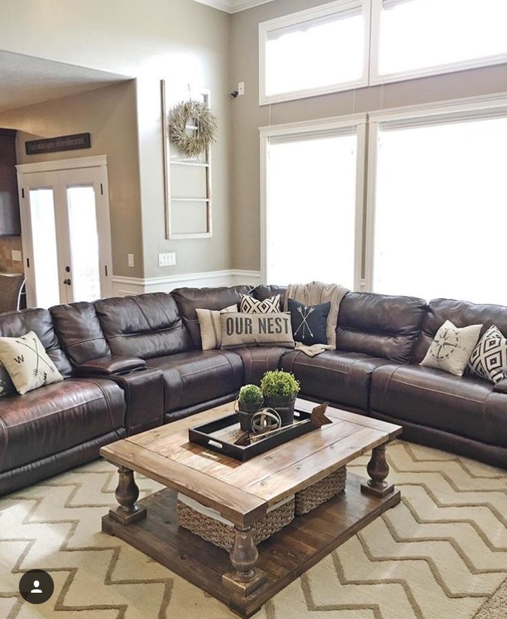 a living room filled with lots of furniture and pillows on top of a coffee table