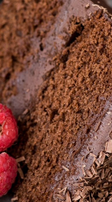 a piece of chocolate cake and three raspberries