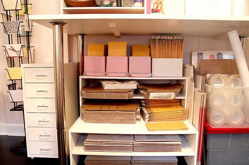 the shelves are full of files and file folders in an organized office area with white shelving