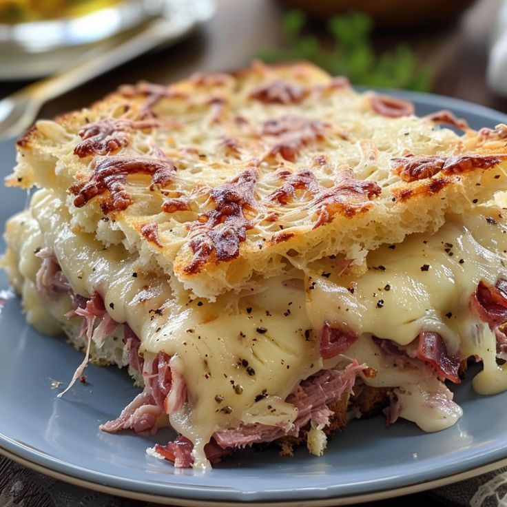 a close up of a plate of food with meat and cheese on it's crust