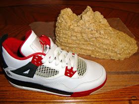 a pair of shoes sitting on top of a wooden floor next to a piece of bread