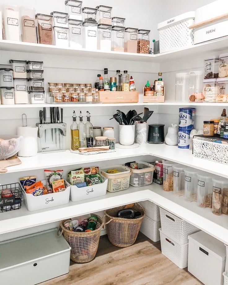 an organized pantry with white shelving and bins