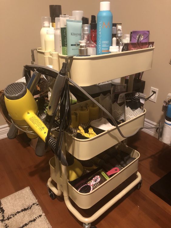 a hairdryer and other items are sitting on a cart in front of a mirror