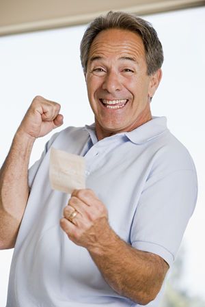 a smiling man holding a piece of paper in his right hand