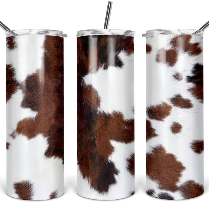 two stainless steel tumblers with brown and white spotted cowhide print, one has a straw in it