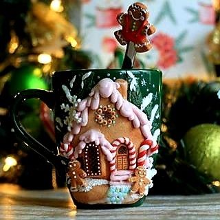 a green coffee cup decorated with gingerbread houses and candy canes