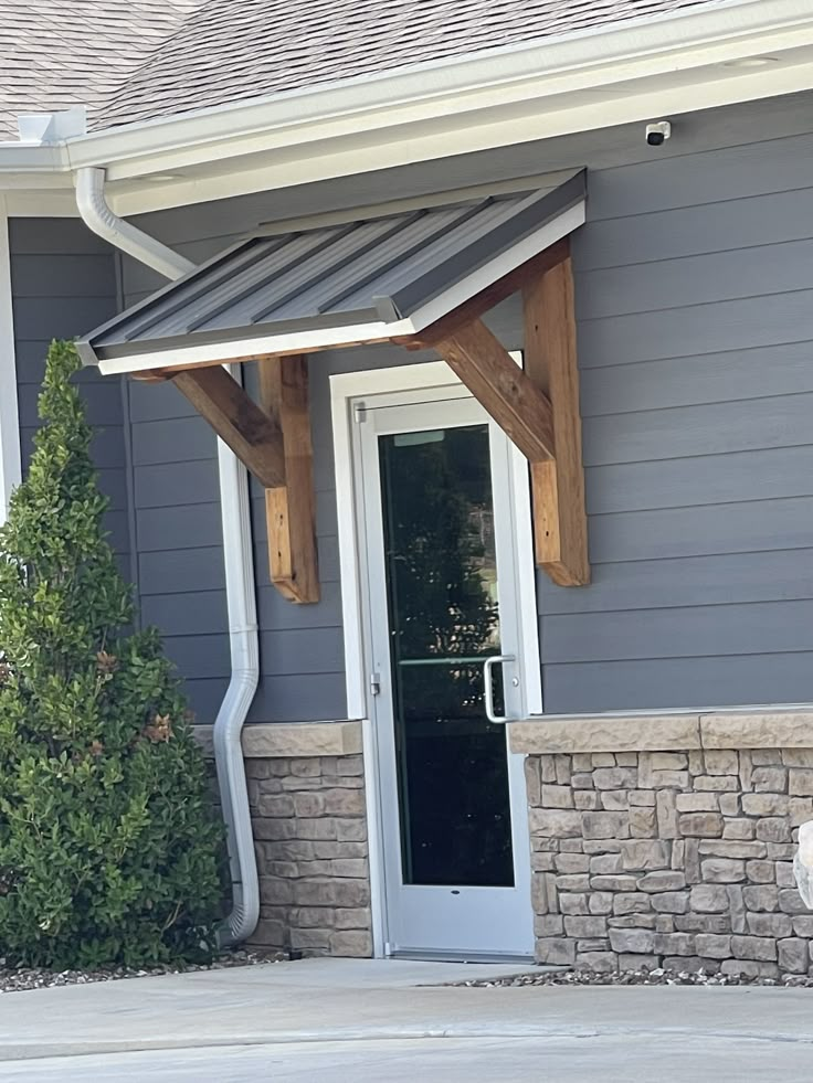 a dog is sitting on the front steps of a house with its door open to let in some light