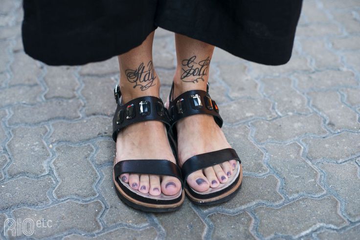 a person with tattoos on their feet wearing sandals