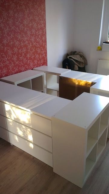 an office desk with several drawers in front of a wallpapered red and white background