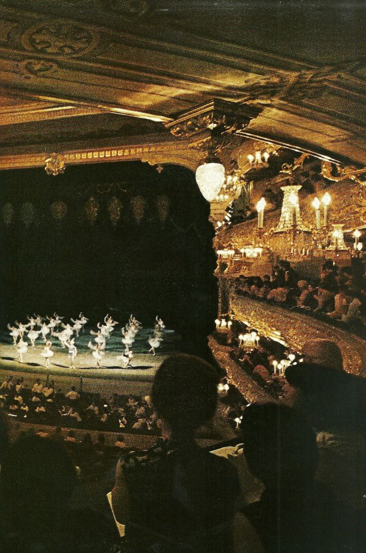 an auditorium filled with lots of people and lights