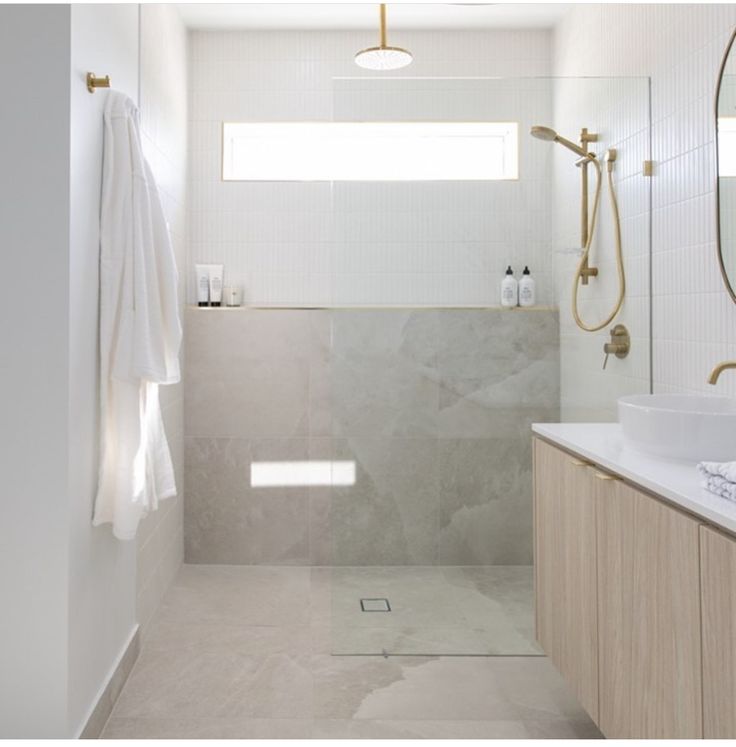 a bathroom with a shower, sink and mirror on the wall next to each other