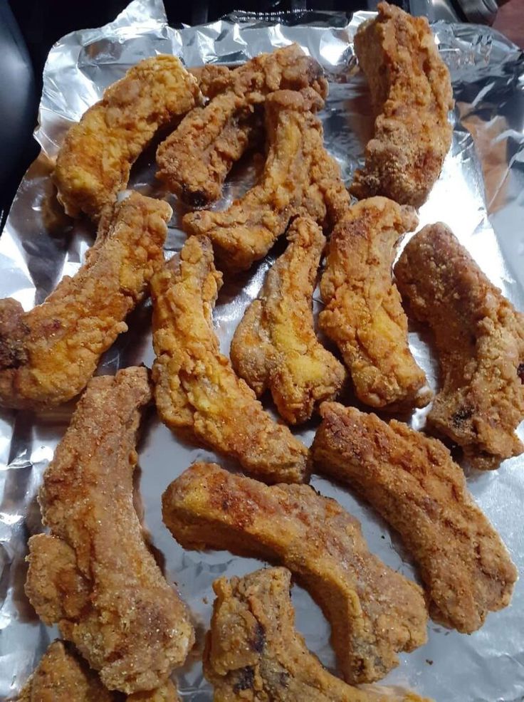 fried chicken strips on tin foil sitting on top of a table