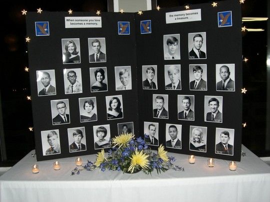 two black and white photos on a table with candles in front of them, surrounded by flowers