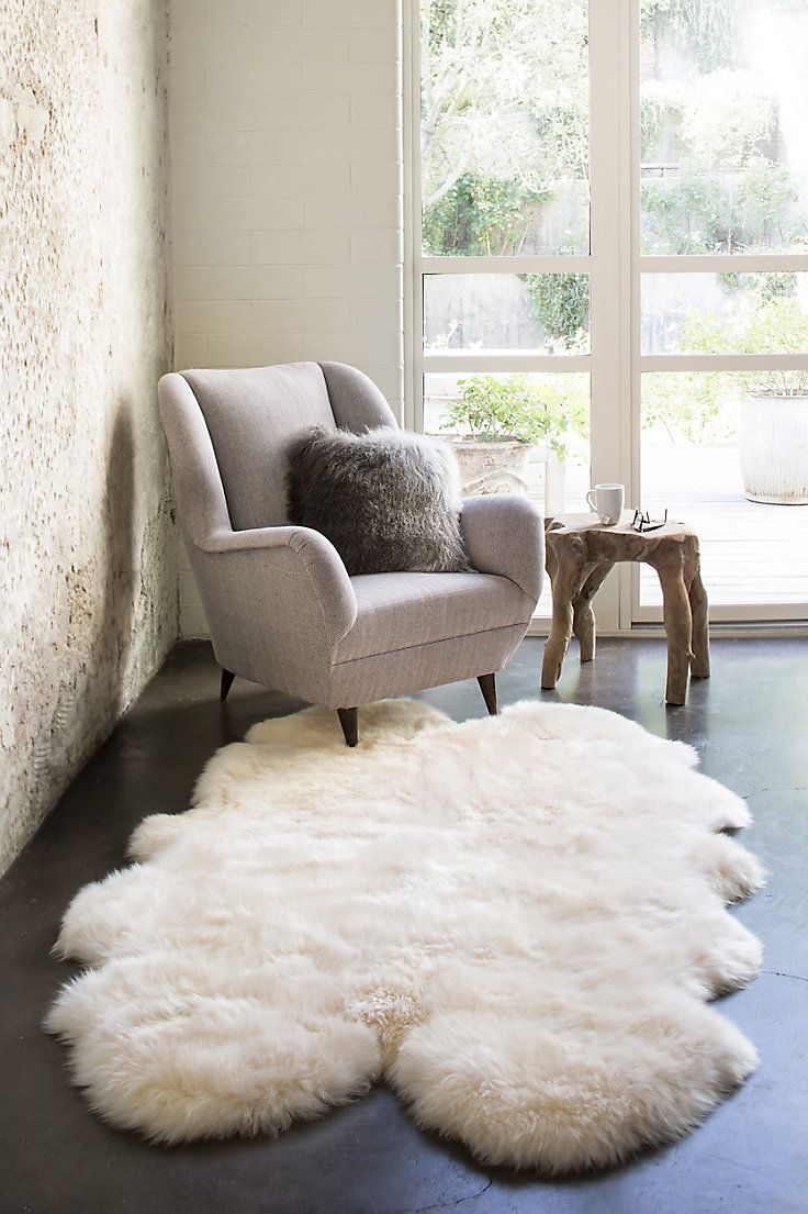 a living room with a chair and sheepskin rug