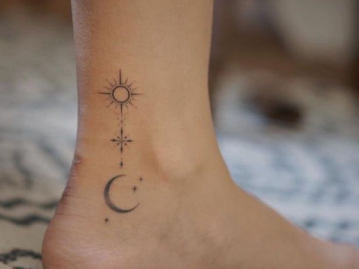 a small tattoo on the foot of a woman's right foot, with a sun and moon