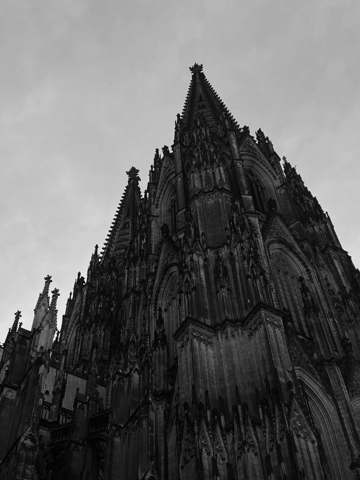 a very tall building with many spires on it's sides and clock at the top