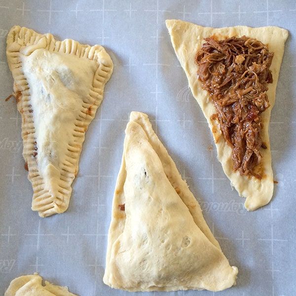 four different types of pastries on a sheet of wax paper with some toppings