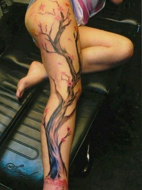 a woman's leg with a tree tattoo on it