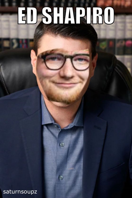 a man with glasses and beard sitting in front of a book shelf that says ed shapiro