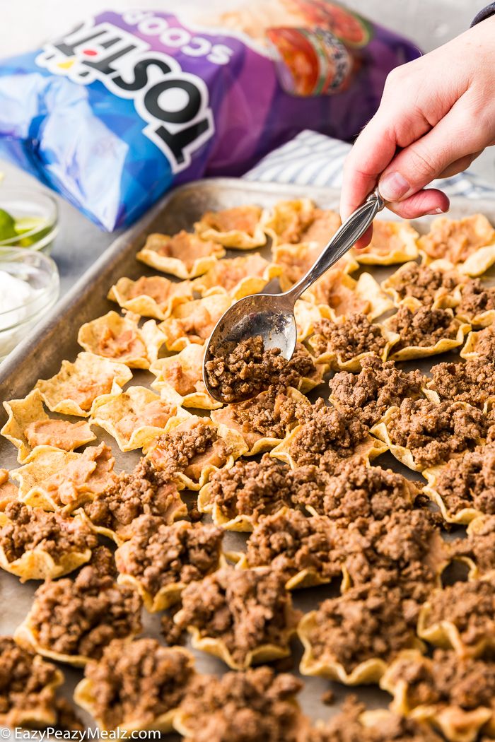 a person scooping some food out of a baking pan with a spoon in it