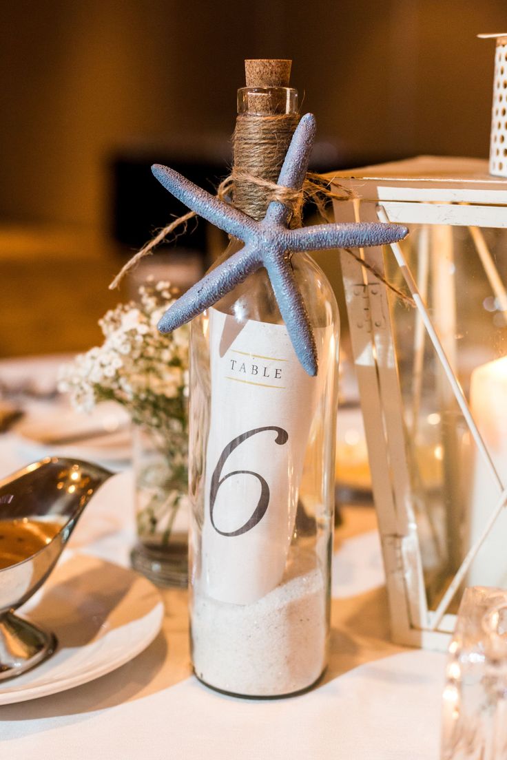 a bottle with a starfish in it sitting on top of a table