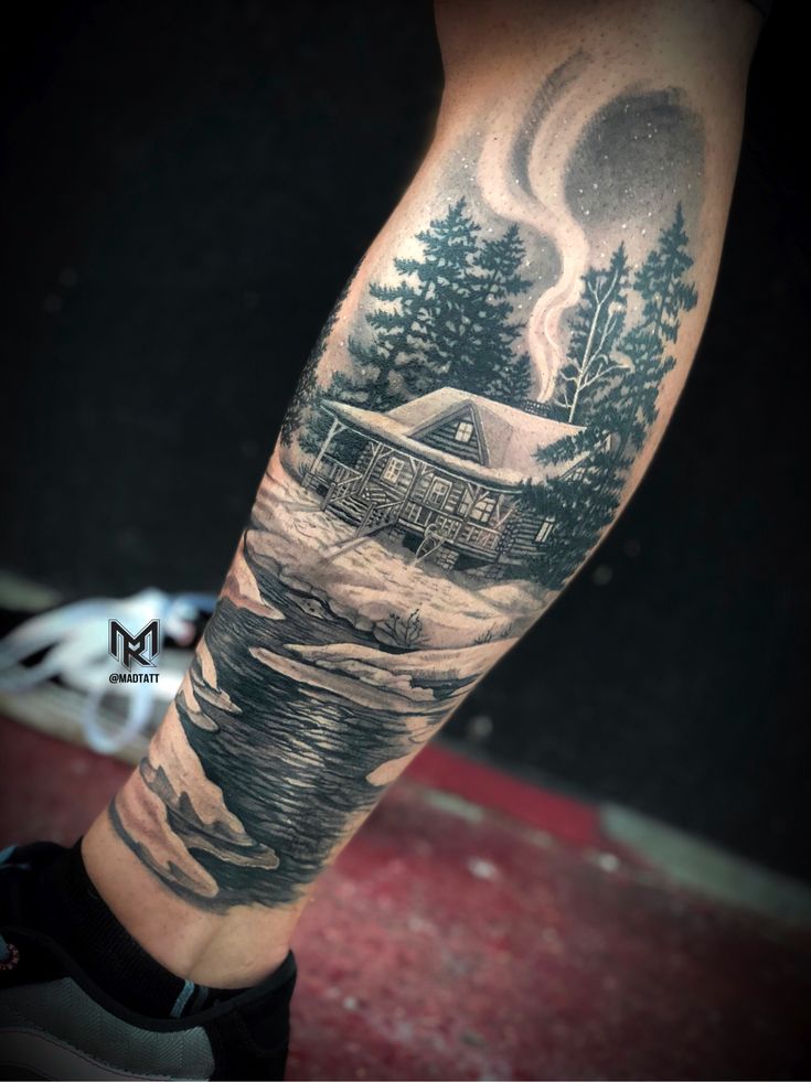 a man's arm with a house and trees on it