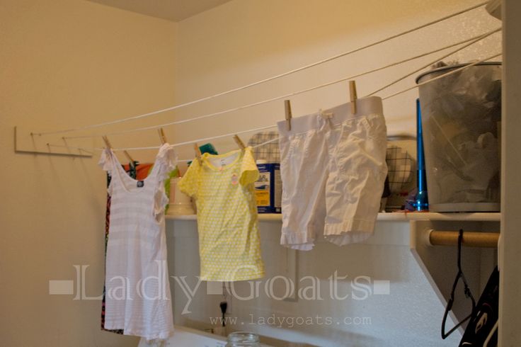 clothes are hanging on the clothesline in this laundry room